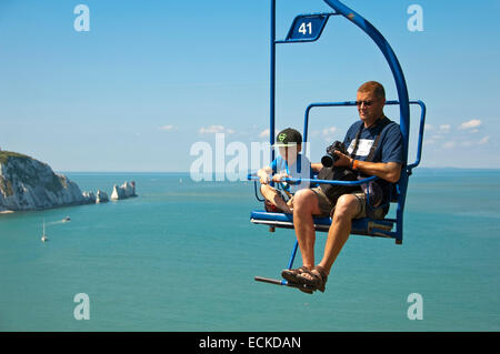 Horizontale Ansicht von Vater und Sohn auf dem Sessellift auf die Nadeln auf der Isle Of Wight. Stockfoto