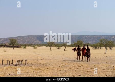 Namibia, Kunene Region, Kaokoland, Himba-Dorf in der Nähe von Opuwo, Himba-Frauen gehen in Richtung des Dorfes Stockfoto