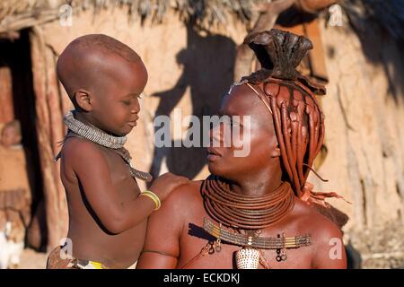 Namibia, Kunene-Region, Kaokoland, Himba-Dorf in der Nähe von Opuwo, Himba-Frau und ihr Kind Stockfoto