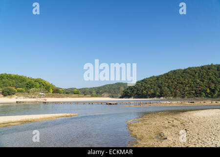 einspurige Log Brücke über einen flachen Fluss in Museom Dorf, Yeongju, Korea. Stockfoto