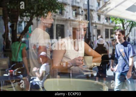 Spanien, Andalusien, Sevilla, Straße der Verfassung, durch Glas Portrait eines Mädchens in einem Coffee-Shop-Innenstadt Stockfoto