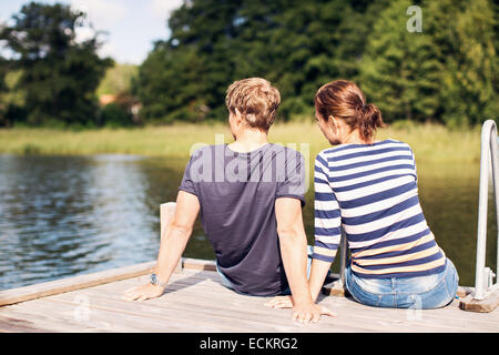 Rückansicht des reifes Paar am Pier am See entspannen Stockfoto