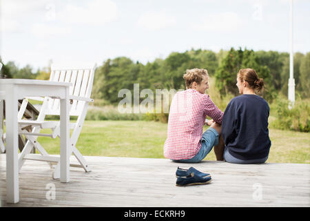 Rückansicht des glücklich älteres paar Kommunikation auf Veranda Stockfoto