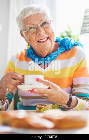 Porträt von glücklich senior Frau Kaffeetrinken im Pflegeheim Stockfoto