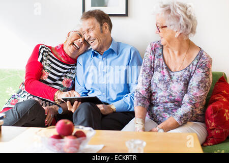 Gerne älteres Paar mit digital-Tablette von Freundin im Pflegeheim Stockfoto