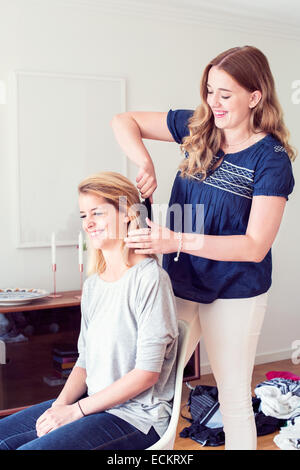 Junge Frau, die Schwester zu Hause Haare Bürsten Stockfoto