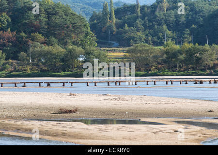 einspurige Log Brücke über einen flachen Fluss in Museom Dorf, Yeongju, Korea. Stockfoto