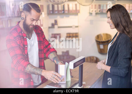 Eigentümer mit einem Gewicht von Bonbons vor Kunden im shop Stockfoto