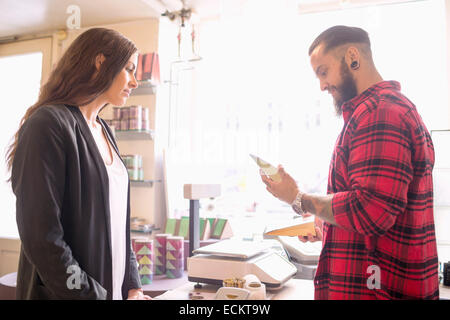 Eigentümer und Kunden betrachten Produkt im Candy shop Stockfoto