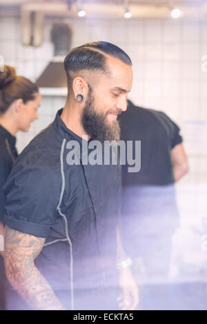 Lächelnd männliche Arbeiter, die Zusammenarbeit mit den Kollegen im Candy shop Stockfoto