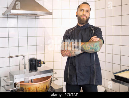 Porträt der männlichen Arbeitnehmer mit Arme gekreuzt stehen im Süßwarenladen Stockfoto