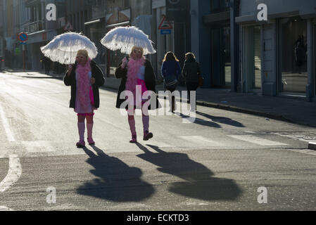 Männer mit Sonnenschirmen, cross-dressed als Frauen in rosa Kleidern in Aalst Karnevalszug, Karneval Montag, Aalst, Belgien Stockfoto