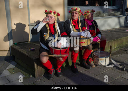 Männer mit Trommeln, cross-dressed als Frauen mit langen blonden Zöpfen, eine Pause von Aalst Karnevalszug, Karneval Montag, Aalst, Belgien Stockfoto