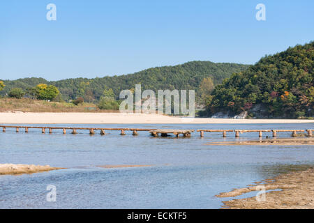 einspurige Log Brücke über einen flachen Fluss in Museom Dorf, Yeongju, Korea. Stockfoto