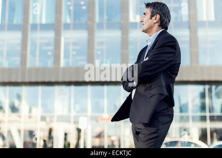 Geschäftsmann mit Arme gekreuzt aussehende Weg außen Bürogebäude Stockfoto