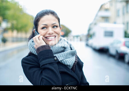 Lächelnd Mitte erwachsenen Frau am Smartphone auf Straße Stockfoto