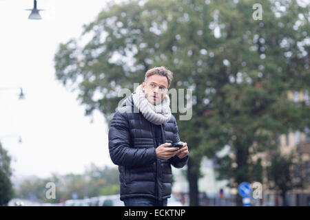 Reifer Mann mit Smartphone auf Straße Stockfoto