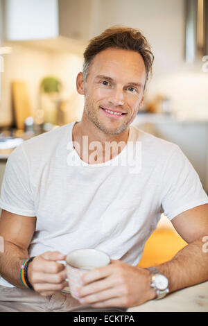 Porträt von lächelnden reifer Mann mit Kaffee zu Hause Stockfoto