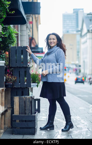 In voller Länge Portrait von lächelnden Frau vor Laden Stockfoto