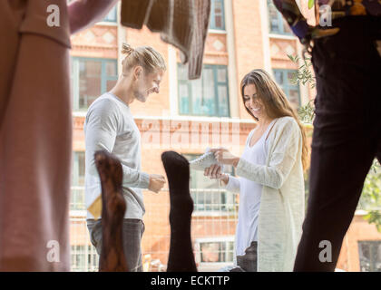 Glücklich Arbeitnehmerin diskutieren mit Besitzer Schuh außerhalb Boutique mit gedrückter Stockfoto