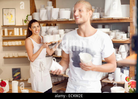 Glückliche Arbeiter, die Vermittlung von handwerklichen Produkten auf Geschirr-workshop Stockfoto