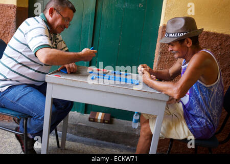 SAO LUIS, Brasilien - 2. Oktober 2013: Brasilianische Männer sitzen Domino spielen an einem Tisch auf der Straße. Stockfoto