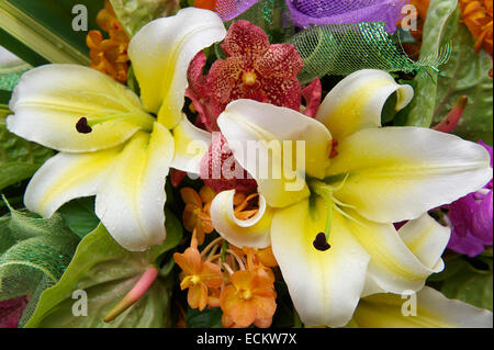 Tropische Blumen versammelten sich in exotischen Blumenstrauß mit weißen Lilien und orange Azalea in ein Angebot in einem Thai-Tempel Stockfoto