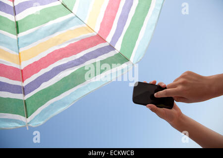 Junger Mann mit Handy am Strand. Stockfoto