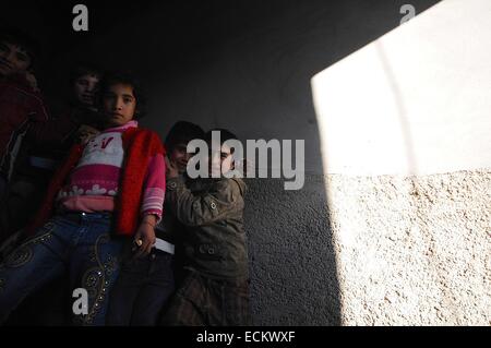 Suruc, Türkei. 16. Dezember 2014. Dutzende von syrischen kurdischen Flüchtlinge gezwungen wurden ihre Heimat wegen der dschihadistische Terrorgruppe der islamischen Staat haben Zuflucht bilden in verlassenen Gebäude neben der syrischen Grenze genommen. Das Gebäude hat keinen Strom und kein fließendes Wasser. Viele verlassen sich auf die Moschee nebenan für warmes Essen und Grundversorgung zu leben. Wie der Winter werden Sätze in vielen gezwungen, in die nahe gelegenen Flüchtlingslager zu bewegen, wo sie auf grundlegende Einrichtungen Zugriff. Bildnachweis: Gail Orenstein/ZUMA Draht/Alamy Live-Nachrichten Stockfoto