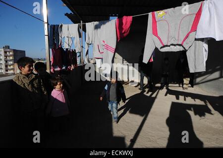 Suruc, Türkei. 16. Dezember 2014. Dutzende von syrischen kurdischen Flüchtlinge gezwungen wurden ihre Heimat wegen der dschihadistische Terrorgruppe der islamischen Staat haben Zuflucht bilden in verlassenen Gebäude neben der syrischen Grenze genommen. Das Gebäude hat keinen Strom und kein fließendes Wasser. Viele verlassen sich auf die Moschee nebenan für warmes Essen und Grundversorgung zu leben. Wie der Winter werden Sätze in vielen gezwungen, in die nahe gelegenen Flüchtlingslager zu bewegen, wo sie auf grundlegende Einrichtungen Zugriff. Bildnachweis: Gail Orenstein/ZUMA Draht/Alamy Live-Nachrichten Stockfoto