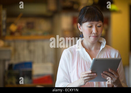 Frau stehend in einem Café, eine digitale-Tablette halten. Stockfoto