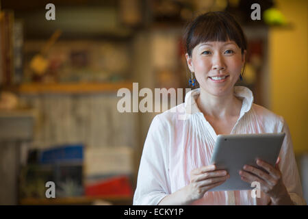 Frau stehend in einem Café, eine digitale-Tablette halten. Stockfoto