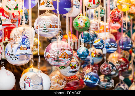 Bunte Weihnachtsglocken hängen in einem traditionellen Weihnachts-Marktstand. Stockfoto