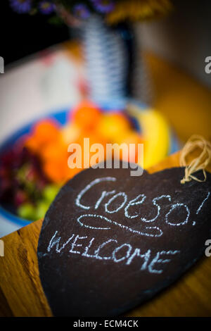 Croeso - die walisische Sprache Wort für Empfang - Hand geschrieben in weißer Kreide auf eine herzförmige Stück Schiefer, Wales UK Stockfoto