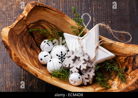 Weihnachtsschmuck Schüssel Glocken aus Olivenholz auf grüne Tanne Äste Hintergrund Stockfoto