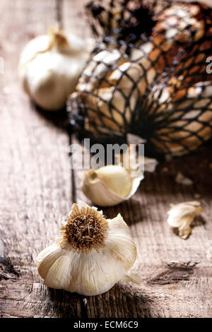 Netzbeutel geräuchertem Knoblauch über hölzerne Hintergrund. Serien ansehen Stockfoto