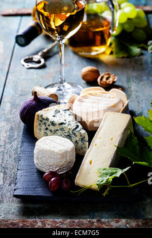 Verschiedene Arten von Käse und Weißwein auf hölzernen Hintergrund Stockfoto