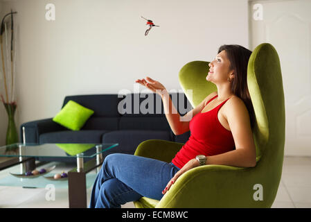 Porträt des jungen Latina Frau spielt mit den Tasten des neuen Hauses, lächelnd und entspannt auf dem sofa Stockfoto