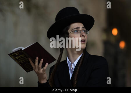 (141217)--JERUSALEM, 17. Dezember 2014 (Xinhua)--ein Ultra-orthodoxe jüdische Mann betet zu Chanukka vor einer großen Hannukiya an der Klagemauer in der Jerusalemer Altstadt am 16. Dezember 2014 zu markieren. Chanukka, auch bekannt als das Festival of Lights und fest von Hingabe, ist eine achttägige jüdischer Feiertag zum Gedenken an die erneute Weihung des heiligen Tempels (der zweite Tempel) in Jerusalem zur Zeit der Makkabäer Revolte gegen Seleucid Reich des 2. Jh. v. Chr. Chanukka für acht Tage und Nächte, beobachtet ist ab dem 25. Tag von Kislev nach dem hebräischen Kalender , die Stockfoto