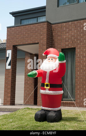 Weihnachten in den Antipoden: ein aufblasbarer Weihnachtsmann in einem vorstädtischen Vorgarten, Melbourne Stockfoto