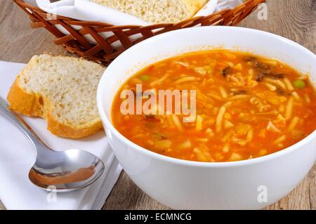 Hausgemachte vegetarische Minestrone-Suppe mit Brot serviert. Stockfoto