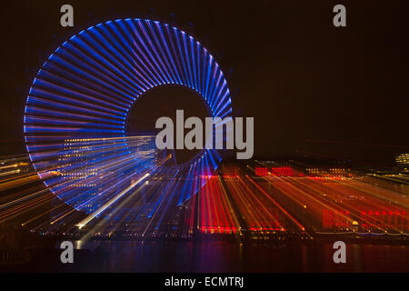 Zoomburst von Gebäuden des London Eye und der Old County Hall, entlang der Themse mit rot beleuchteter Fassade in London UK im Dezember - abstrakter Effekt Stockfoto