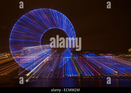 Zoomburst von Gebäuden des London Eye und der Old County Hall, entlang der Themse mit blau beleuchteter Fassade in London UK im Dezember - abstrakter Effekt Stockfoto