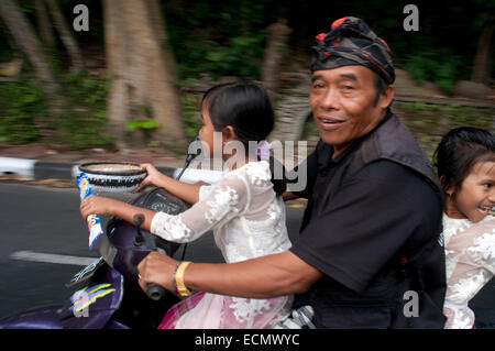 Familie in einem Motorrad. Viele Menschen den Kopf zu dem heiligen Buch Monkey Forest zu beten und Opfergaben für die Feier des Galung verlassen Stockfoto