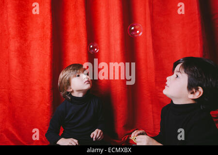 Zwei jungen tragen schwarze Kleidung mit Suppe Luftblasen auf einem Satz spielen Stockfoto