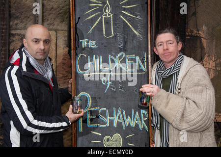 Liverpool, Merseyside, Großbritannien. Dezember 2014. 'Beleuchtend a Candle'  Erinnern An die Kinder von Peschawar sind Tom Calderwell und Chris Jones in St Luke's Church, Liverpool, eine ehemalige anglikanische Pfarrkirche, die heute eine Ruine ist. Die Kirche wurde zwischen den Jahren von 1810 bis 1810 erbaut und von John Foster, Senior und John Foster, Junior, Vater und Sohn, entworfen, die aufeinanderfolgende Vermessungsingenieure für die Munizipalität Liverpool waren. Sie wurde im Zuge des Liverpooler Blitzes im Jahr 1941 schwer beschädigt und bleibt als roofless Schale erhalten. Stockfoto