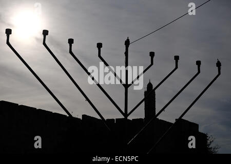Ein "Chanukkiah", eine acht verzweigte Menora oder Kandelaber, befindet sich unterhalb der frühen muslimischen Periode Rundturm, bekannt als der Turm von David, in Vorbereitung für Chanukka, ein jüdisches Fest zum Gedenken an die 164 v. Chr. erneute Weihung des zweiten Tempels in Jerusalem nach seiner Schändung von der herrschenden Seleucid (syrische Griechisch) Königreich unter Antiochus IV. Stockfoto