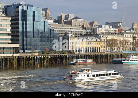 Neue Gebäuden umgeben Londoner original Billingsgate Market aufbauend auf der Themse. Ein Touristenboot übergibt. Stockfoto