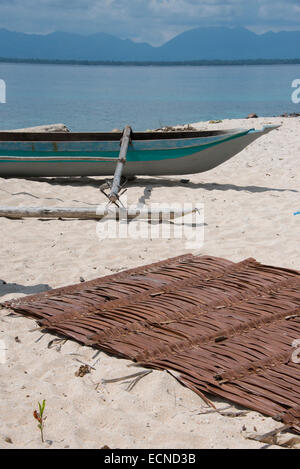 Melanesien, Papua-Neu-Guinea. Kleine Insel von Ali vor der Küste des Festlands PNG. Palm-Matte mit traditionellen Boot am Strand. Stockfoto