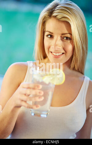 Mädchen trinken Glas Eiswasser mit Zitrone Stockfoto